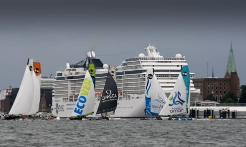 Extreme Sailing Series Fleet Extreme Sailing Series Fleet crosses by a cruise ship in Kiel ( Photo by Paul Wyeth / OC Events )